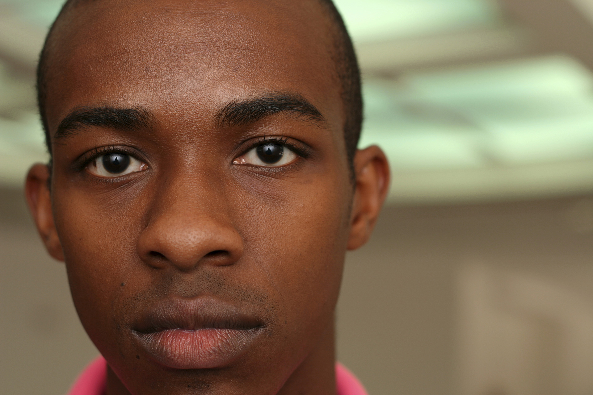 A close-up of a man looking into the camera with a discontent look on his face. 